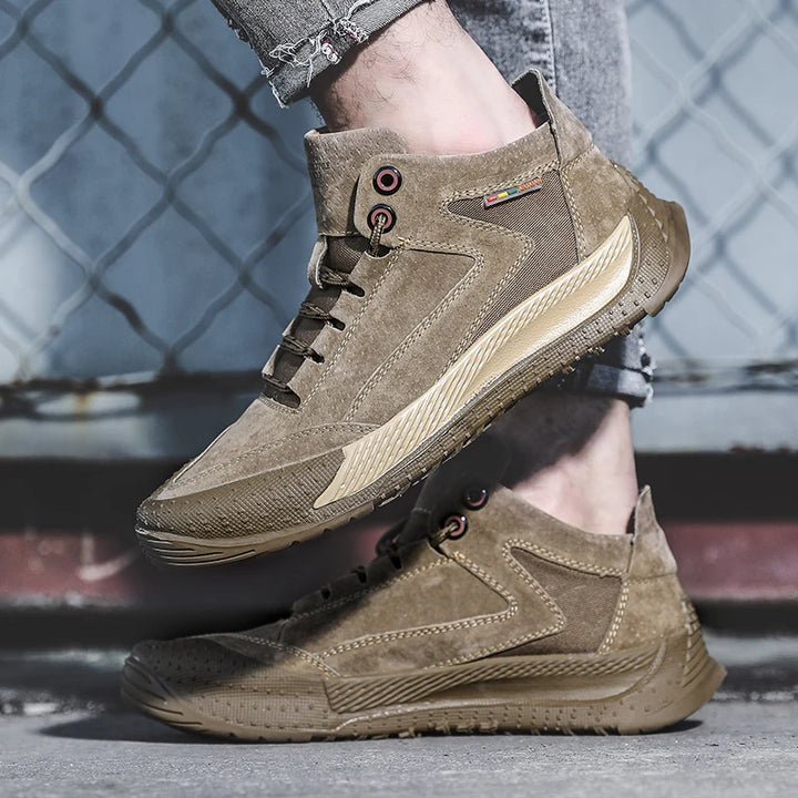 Brown suede boots worn with jeans against a chain-link fence background