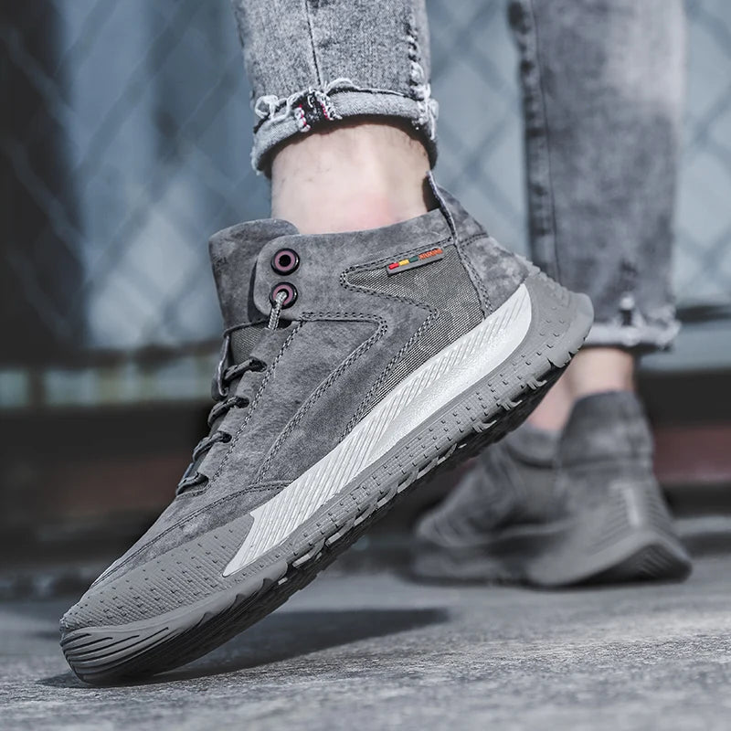 Gray suede shoes worn with jeans on a blurred background