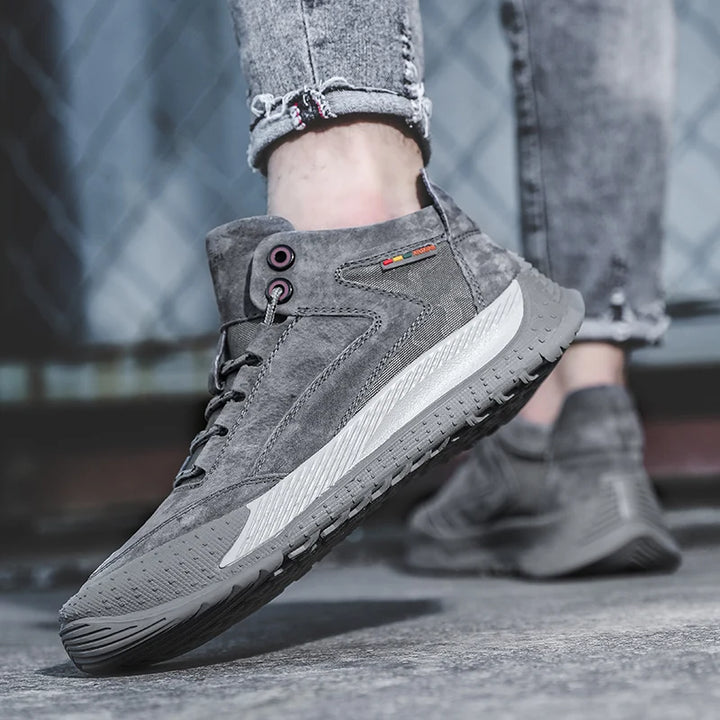 Gray suede shoes worn with jeans on a blurred background
