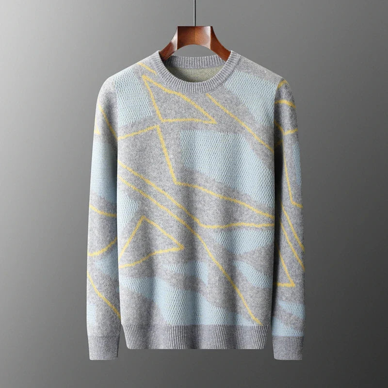 Gray sweater with yellow geometric patterns on a hanger against a gray background