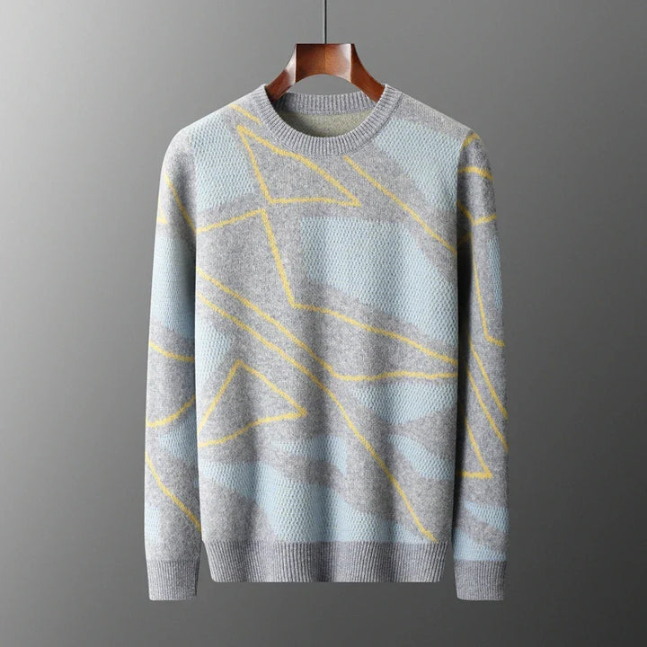 Gray sweater with yellow geometric patterns on a hanger against a gray background