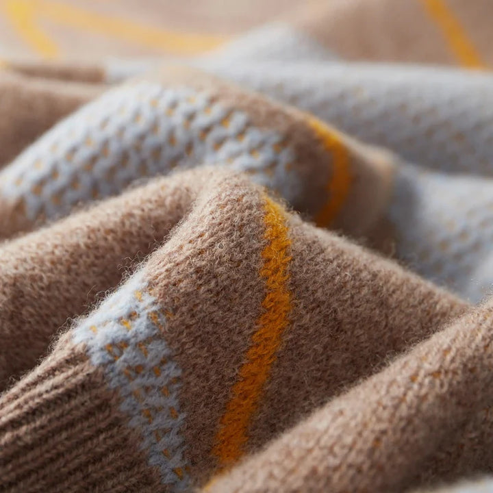 Close-up of a knitted fabric with brown, gray, and orange colors.