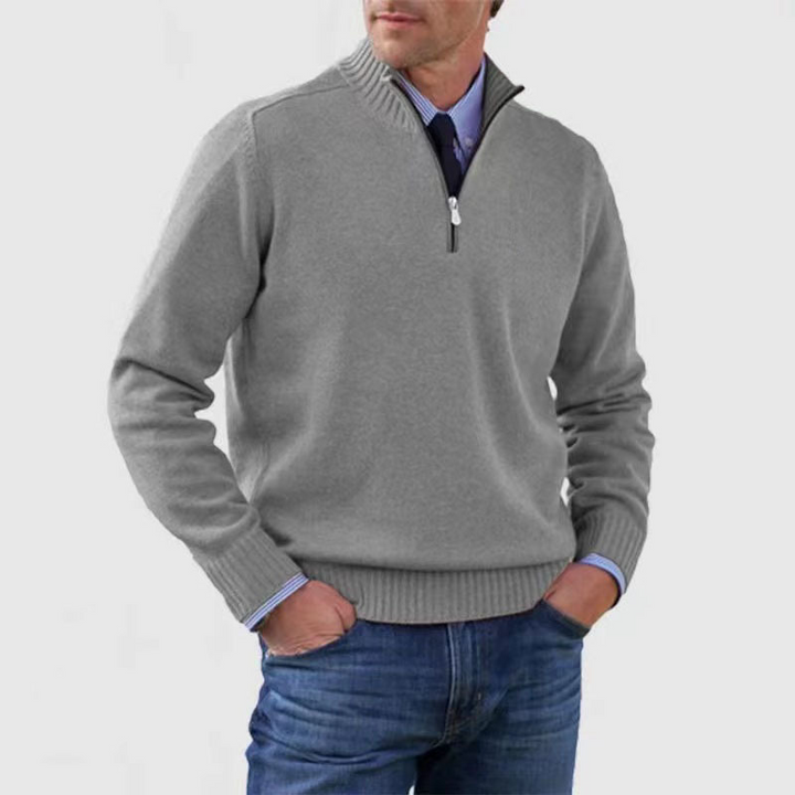 Man wearing a gray quarter-zip sweater with a white background