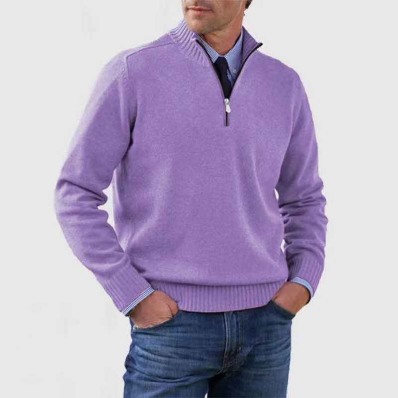 Man wearing a purple quarter-zip sweater and blue jeans on a white background