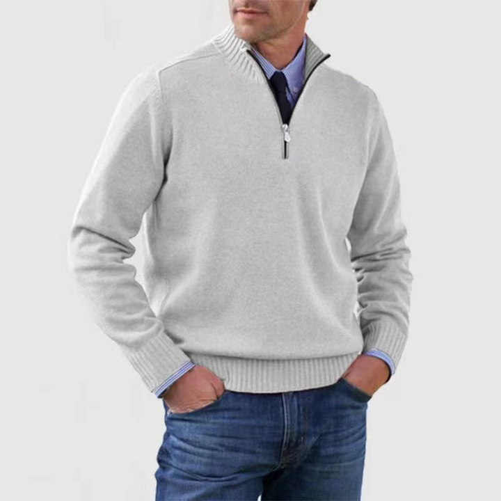 Man wearing a gray quarter-zip sweater with a white background