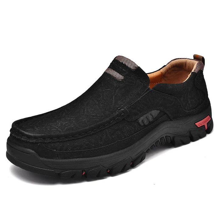 Black slip-on shoe with brown lining on a white background