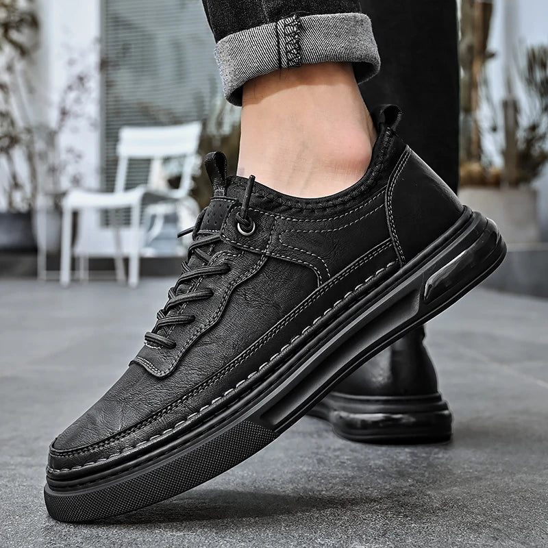 Black leather sneaker worn on a blurred outdoor background