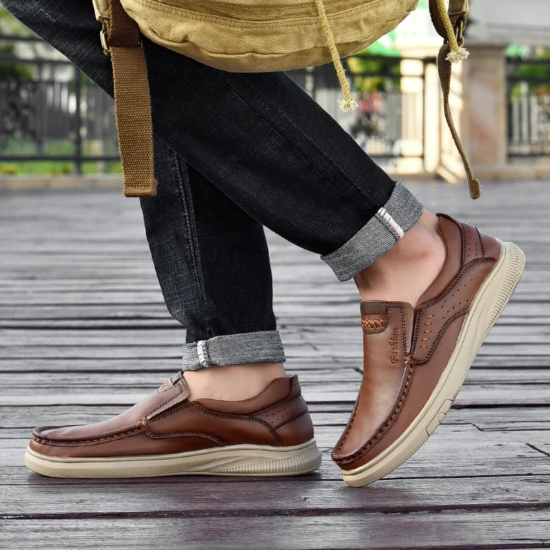 Person wearing brown leather shoes on a wooden floor
