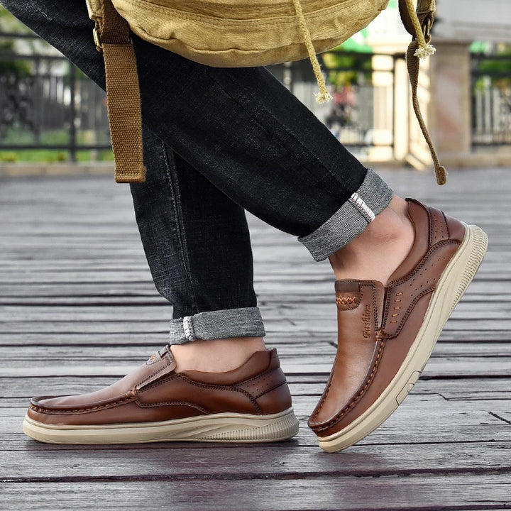 Person wearing brown leather shoes on a wooden floor