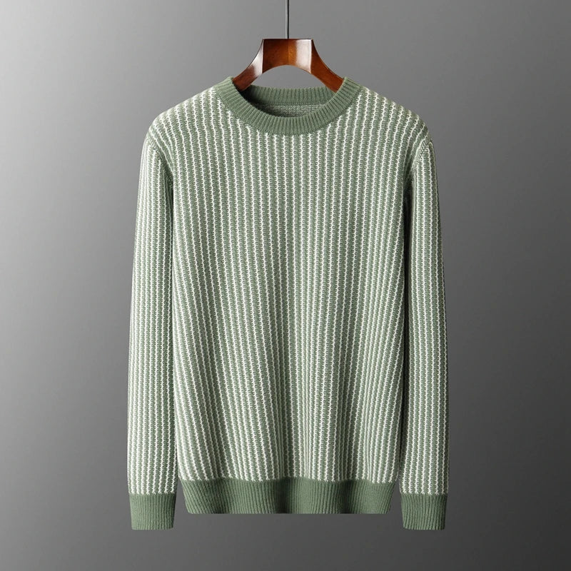 Green sweater on a hanger against a gray background