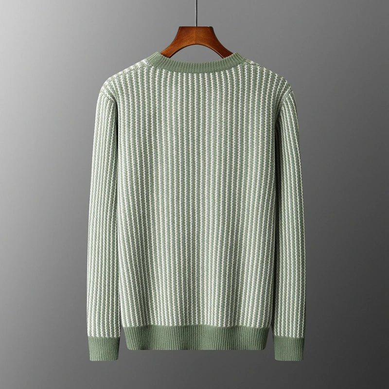 Green and white striped sweater on a hanger against a gray background