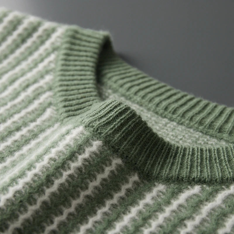 Close-up of a green and white striped sweater with a blurred gray background