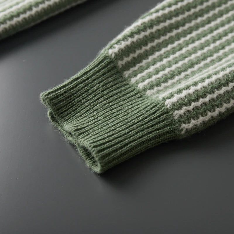 Close-up of a green and white striped sweater sleeve on a dark surface