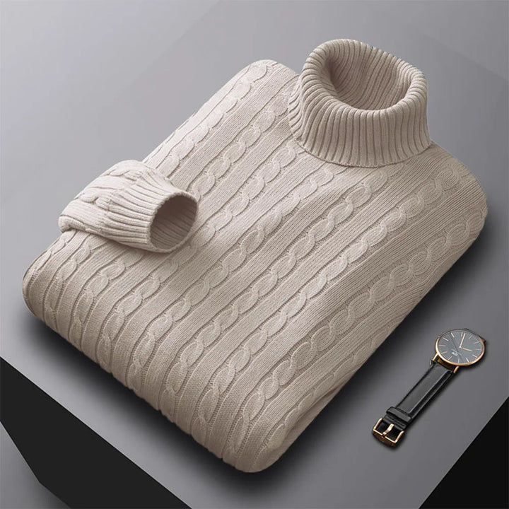 Beige knitted sweater with cable pattern on a gray background