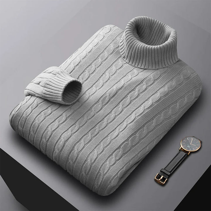 Gray cable knit sweater with a watch on a gray background