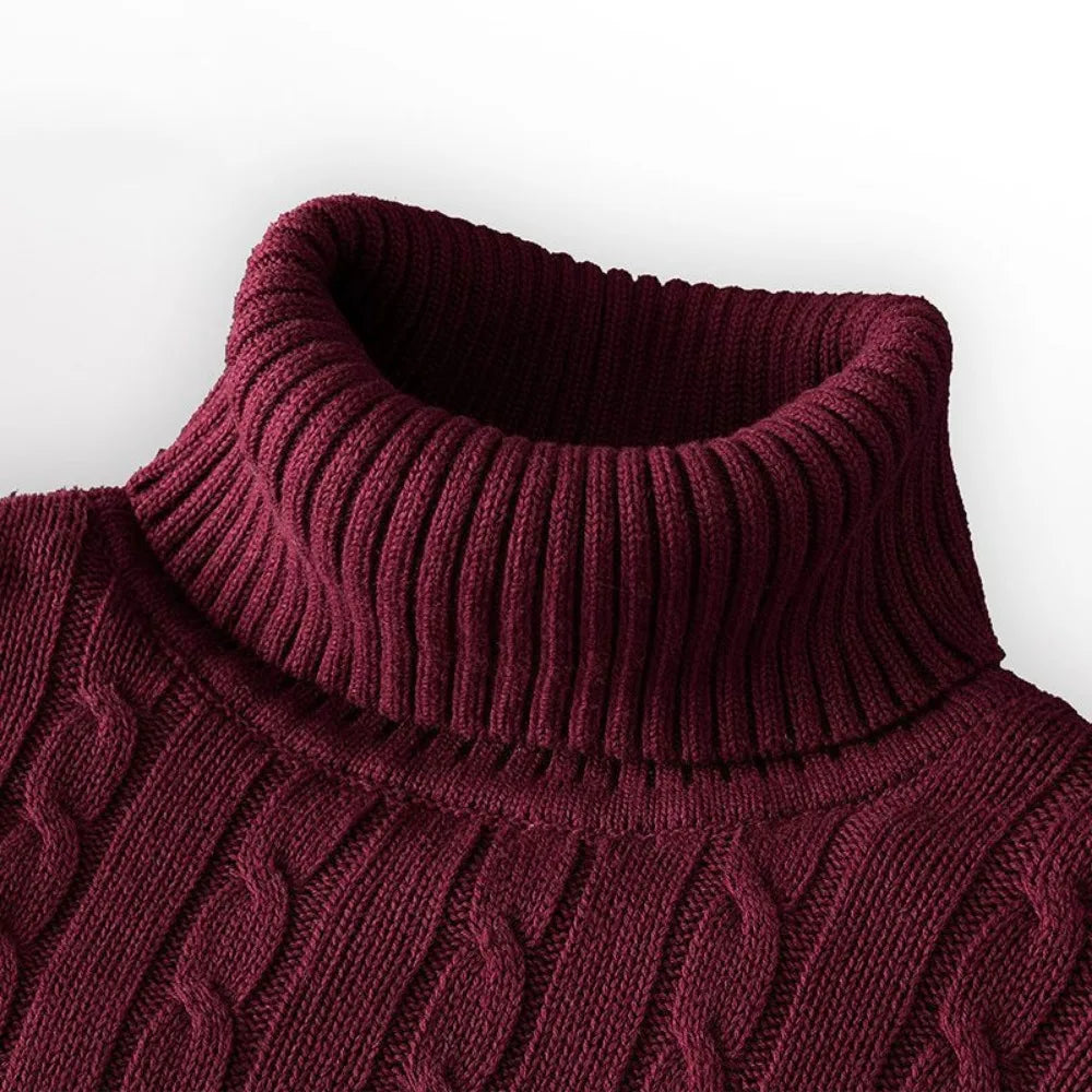 Close-up of a maroon cable knit sweater on a white background