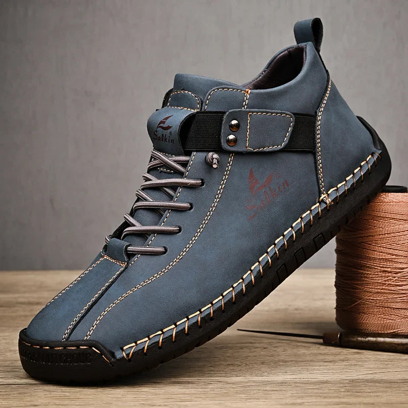Blue leather shoe with black accents on a wooden surface