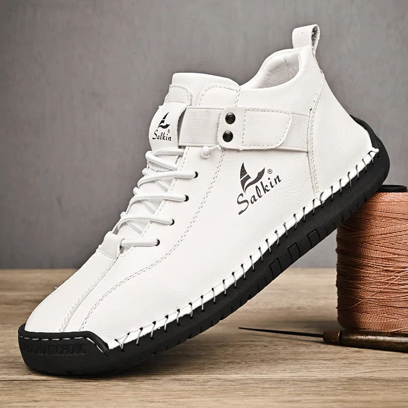 White sneaker with black sole on a wooden surface, featuring the brand 'Salkin'.
