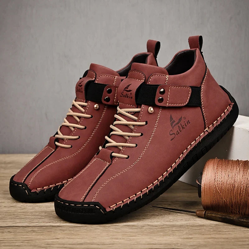 Brown leather shoes with black soles on a wooden surface, featuring the brand 'Salkin'.