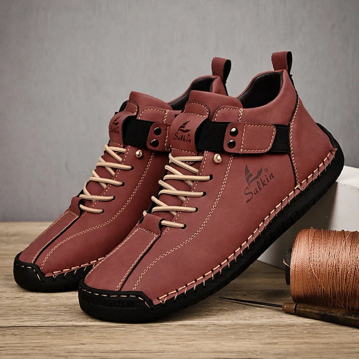 Brown leather shoes with black soles on a wooden surface, featuring the brand 'Salkin'.