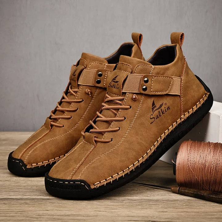 Pair of brown leather shoes with black soles on a wooden surface.