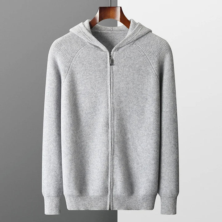 Gray zip-up hoodie on a hanger against a gray background