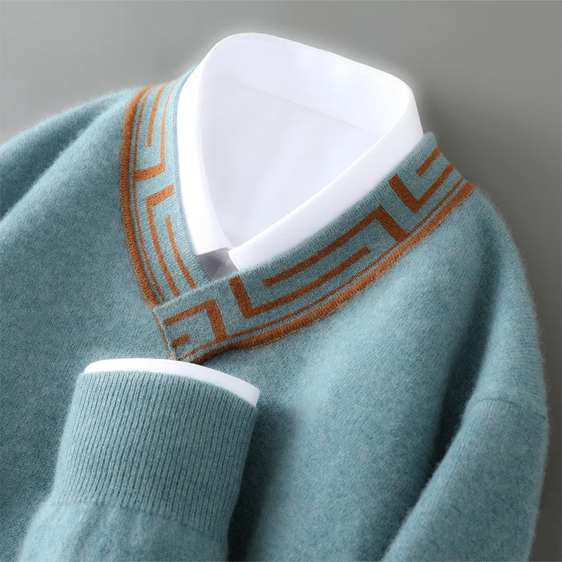 Teal sweater with brown pattern on neckline against a gray background