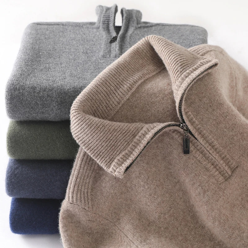 Stack of folded sweaters in gray, brown, and blue on a white background
