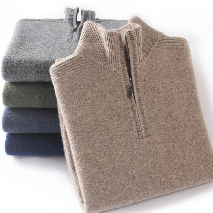 Folded quarter-zip sweaters in gray, green, and blue on a white background