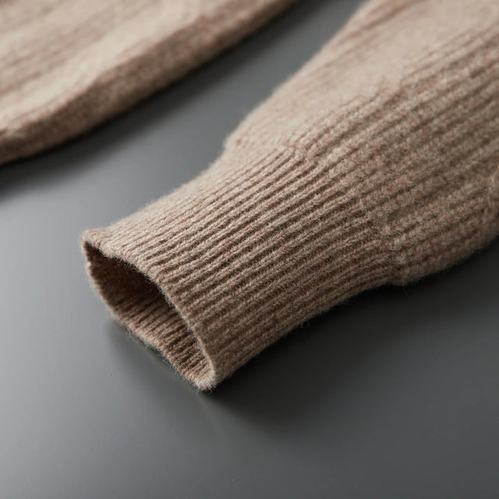 Close-up of a brown knitted sleeve on a dark surface