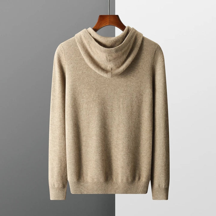 Beige hoodie on a hanger against a gray background