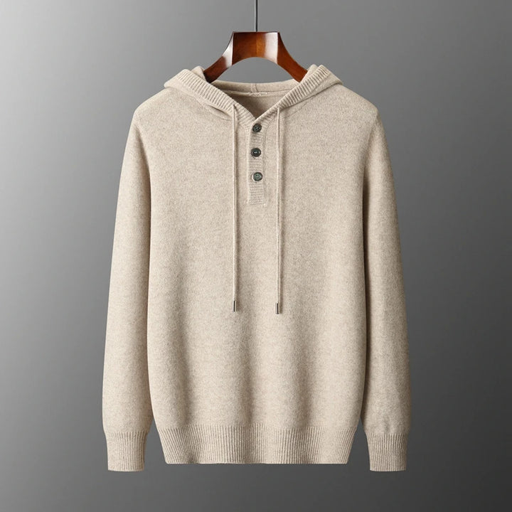 Beige hoodie on a wooden hanger against a gray background