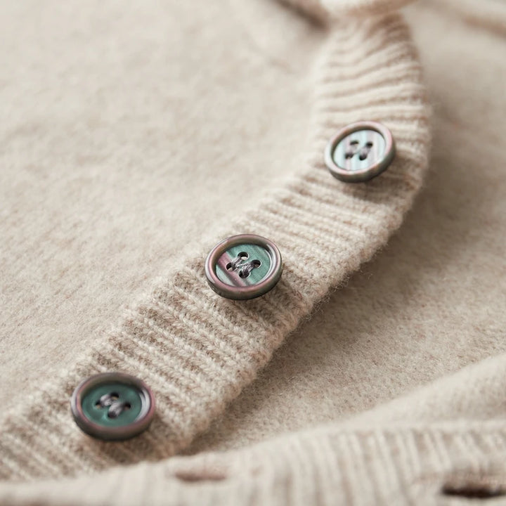 Close-up of a beige textured fabric with buttons on a light background