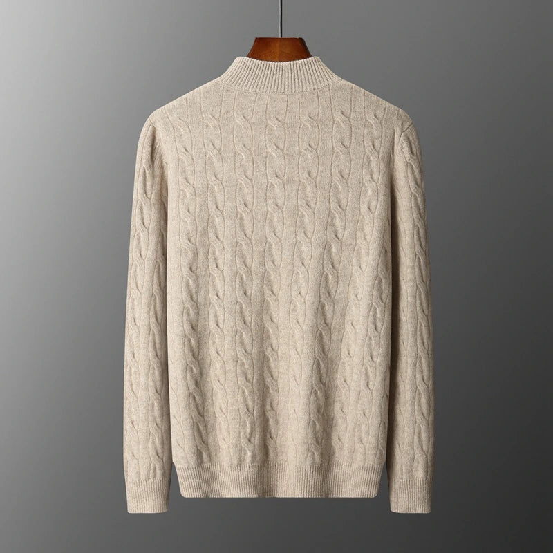 Beige cable knit sweater on a gray background