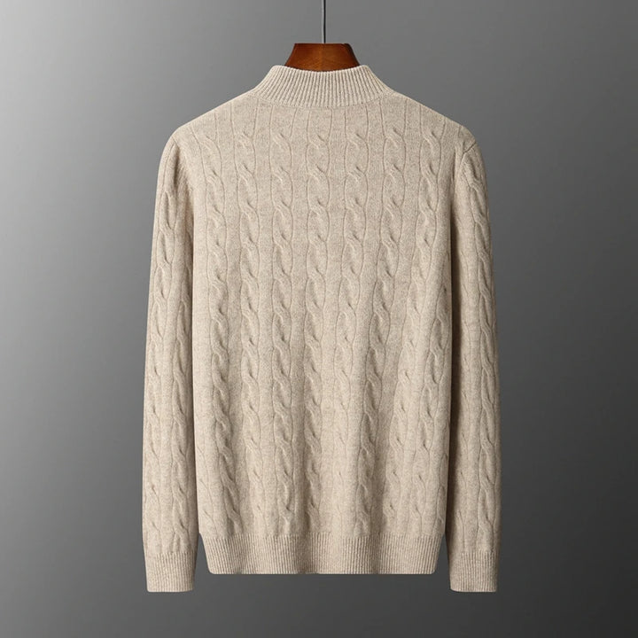 Beige cable knit sweater on a gray background