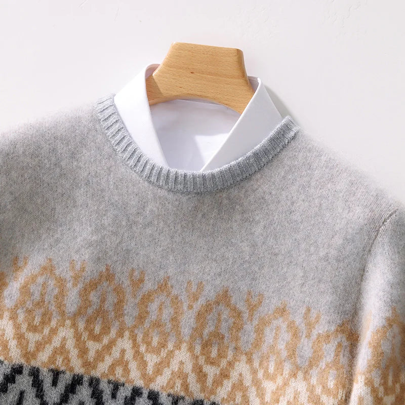 Gray sweater with a pattern on a wooden hanger against a white background