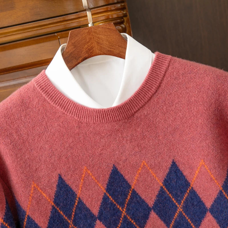 Red sweater with blue and orange diamond pattern on a wooden hanger.