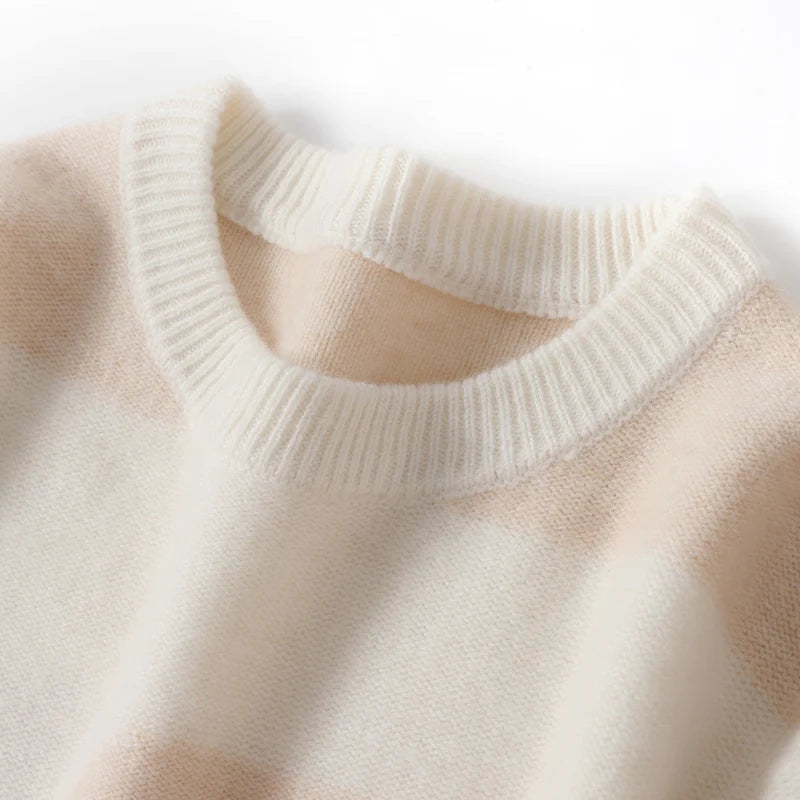 Close-up of a beige sweater with a ribbed neckline on a light background