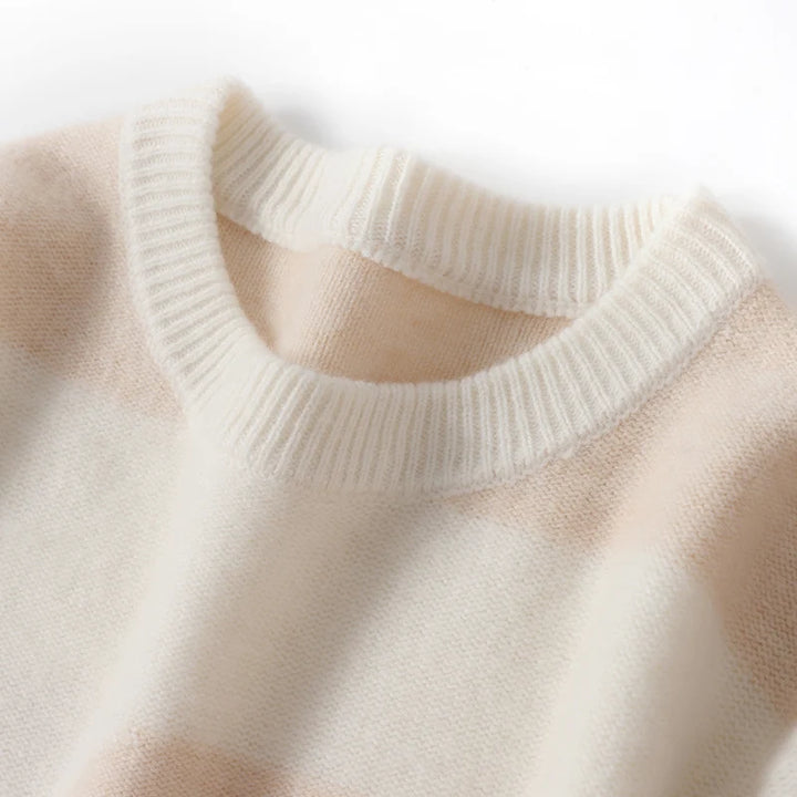 Close-up of a beige sweater with a ribbed neckline on a light background