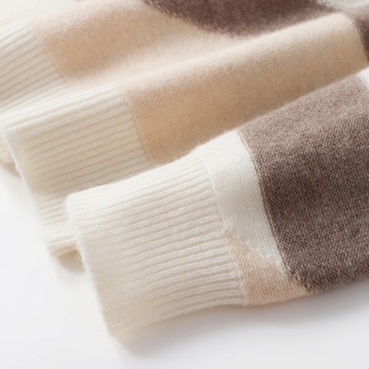 Close-up of a folded sweater with beige and brown stripes on a white background