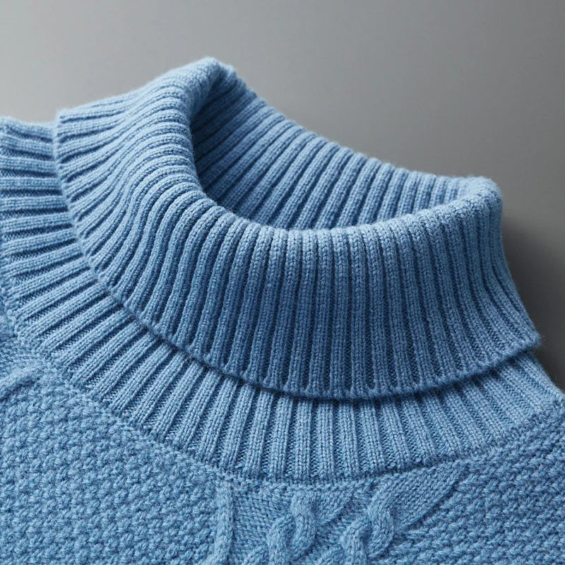 Close-up of a blue knitted sweater with a high collar on a gray background