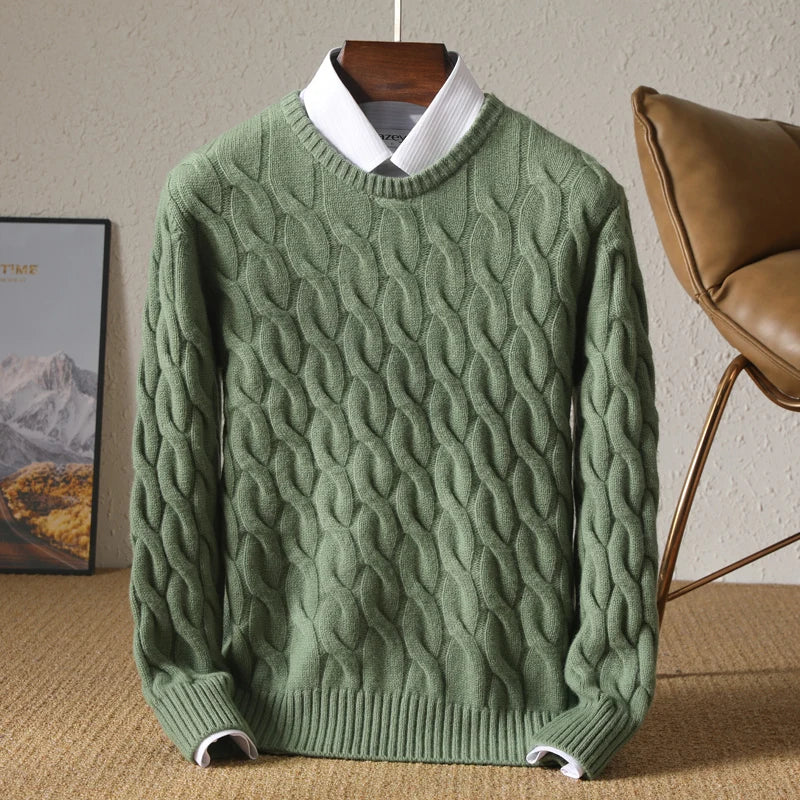 Green cable knit sweater on a hanger against a neutral background
