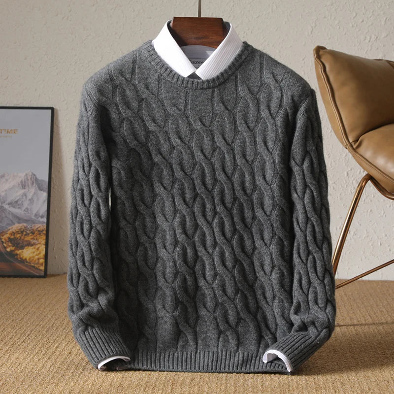 Gray cable knit sweater on a hanger against a neutral background
