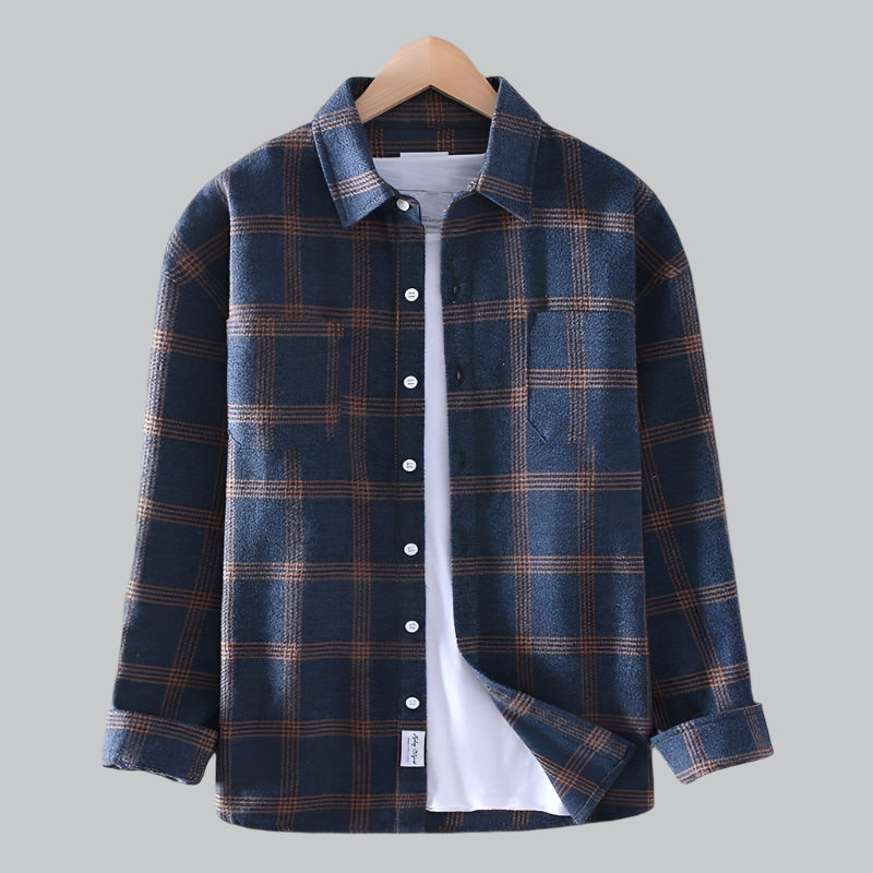 Blue plaid shirt on a hanger against a gray background