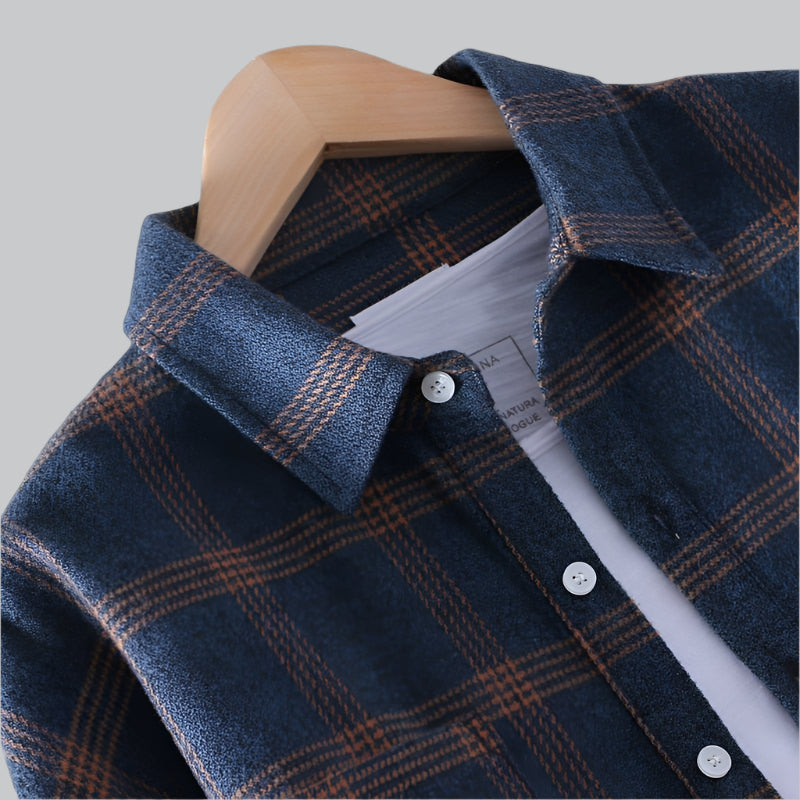 Blue plaid shirt on a wooden hanger against a gray background
