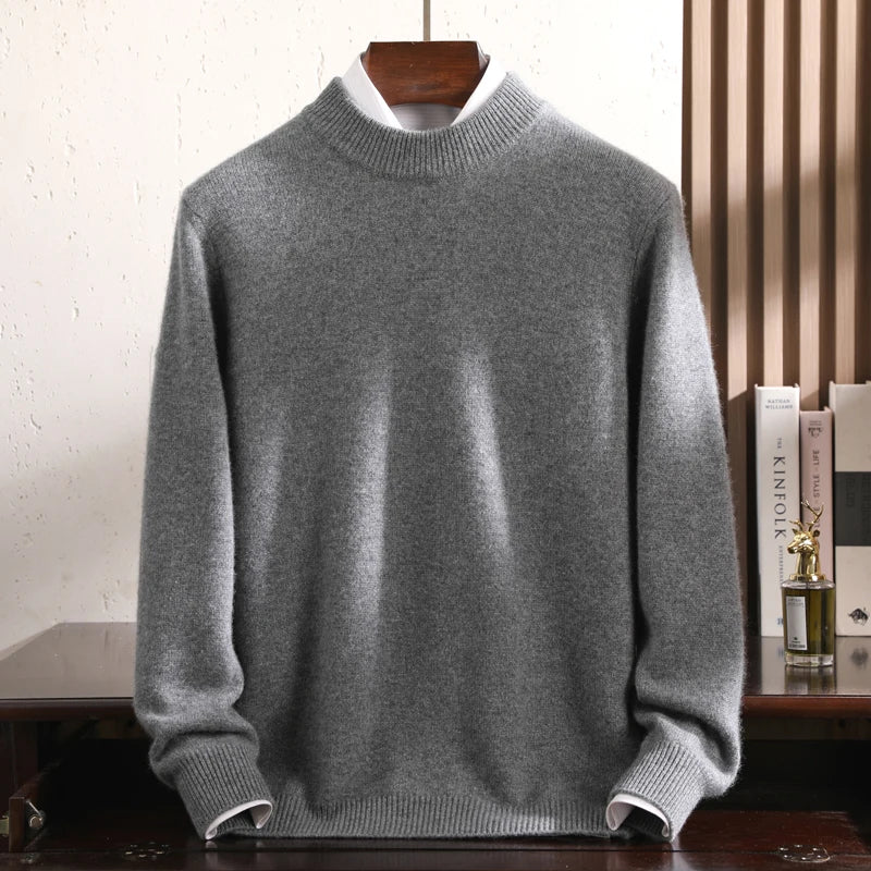 Gray sweater on a wooden hanger against a white wall.