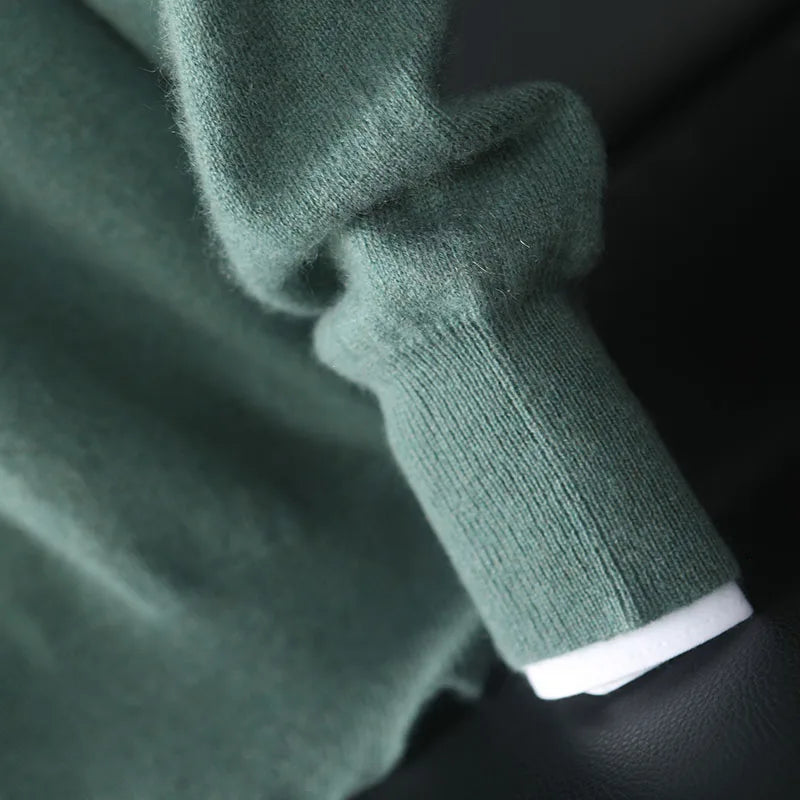 Close-up of a green knitted sweater sleeve with a blurred background