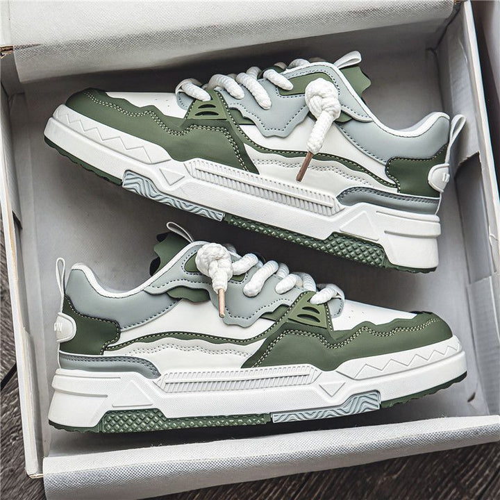 Green and white sneakers in a box on a wooden surface