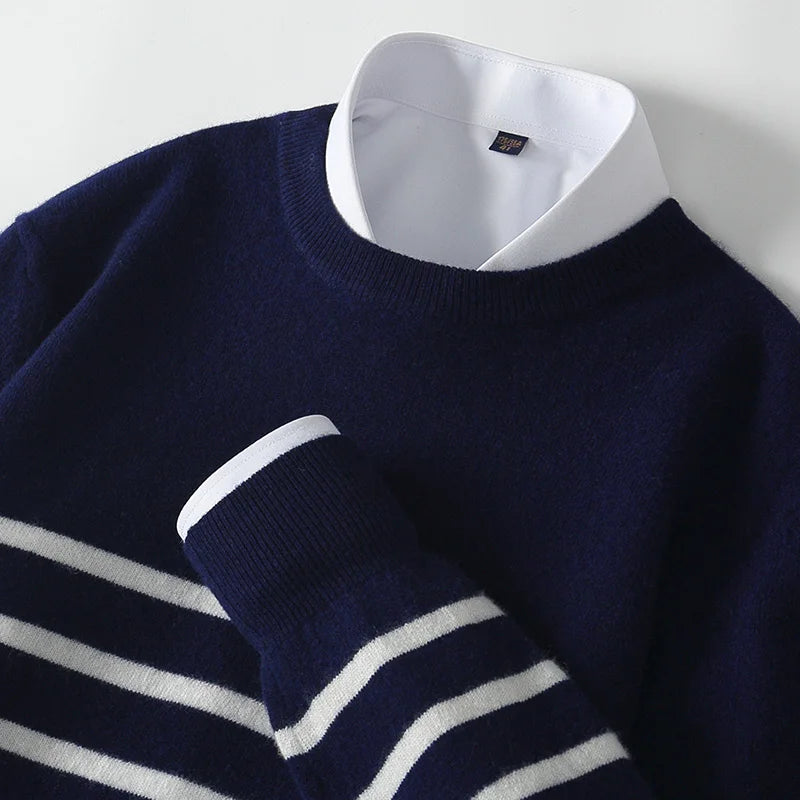 Navy sweater with white stripes over a white shirt on a light gray background