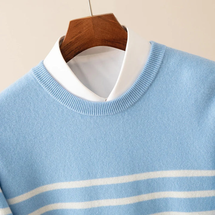 Light blue sweater with white stripes on a wooden hanger against a beige background